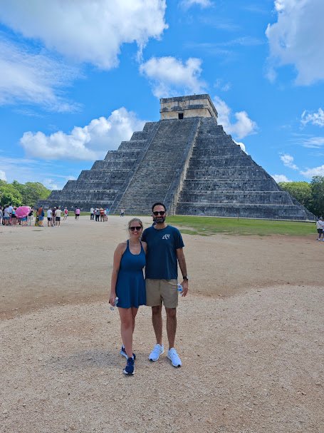 Travelers exploring Chichen Itza with guides